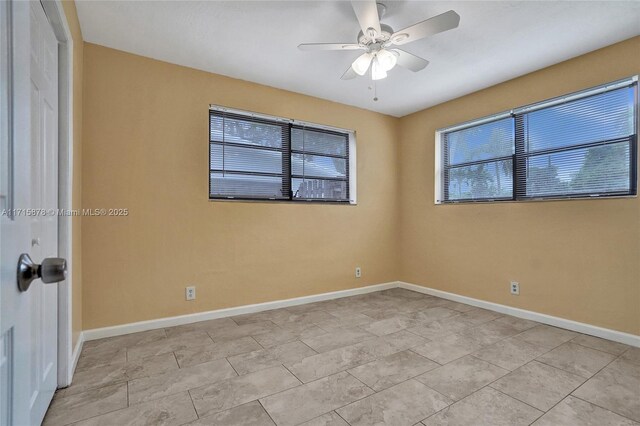 empty room with ceiling fan and light tile patterned flooring