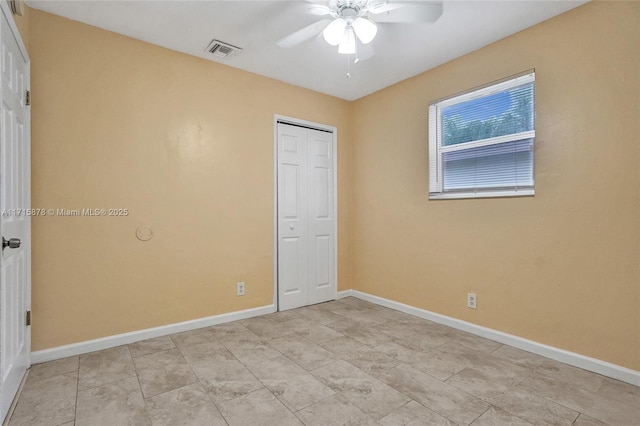 unfurnished bedroom with ceiling fan and a closet