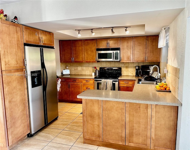 kitchen featuring kitchen peninsula, appliances with stainless steel finishes, light tile patterned floors, and sink