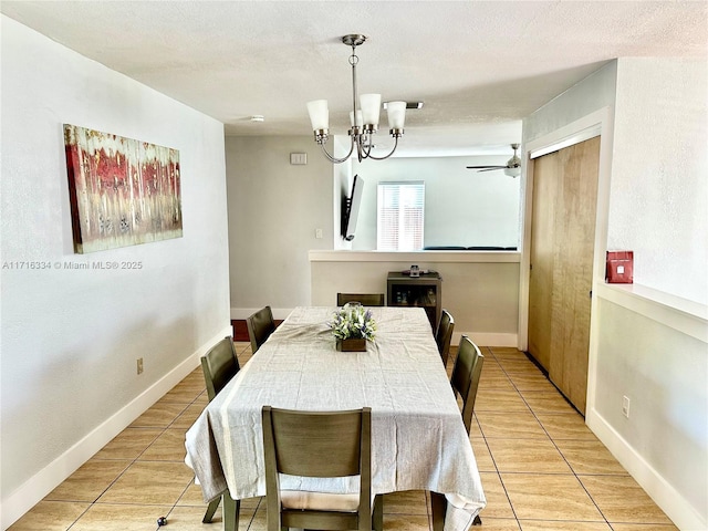 tiled dining area featuring ceiling fan with notable chandelier