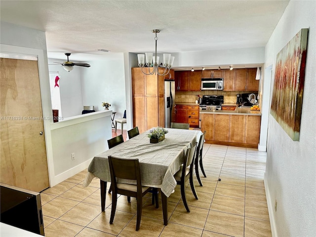 dining room featuring light tile patterned floors and ceiling fan with notable chandelier