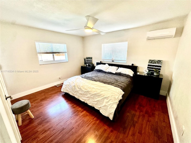 bedroom with dark hardwood / wood-style flooring, an AC wall unit, and ceiling fan