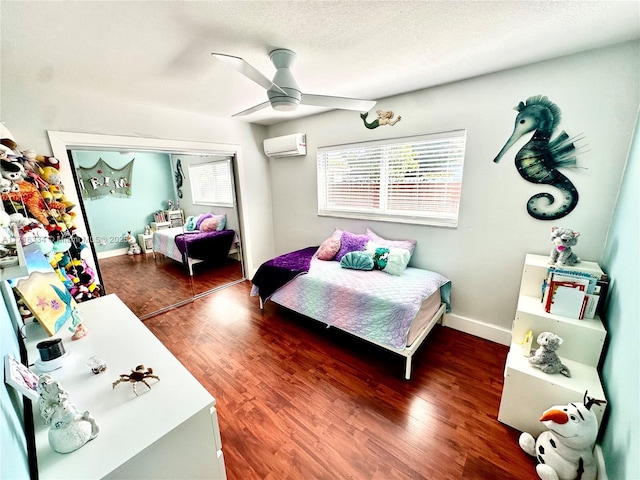 bedroom with a closet, an AC wall unit, ceiling fan, and dark hardwood / wood-style floors