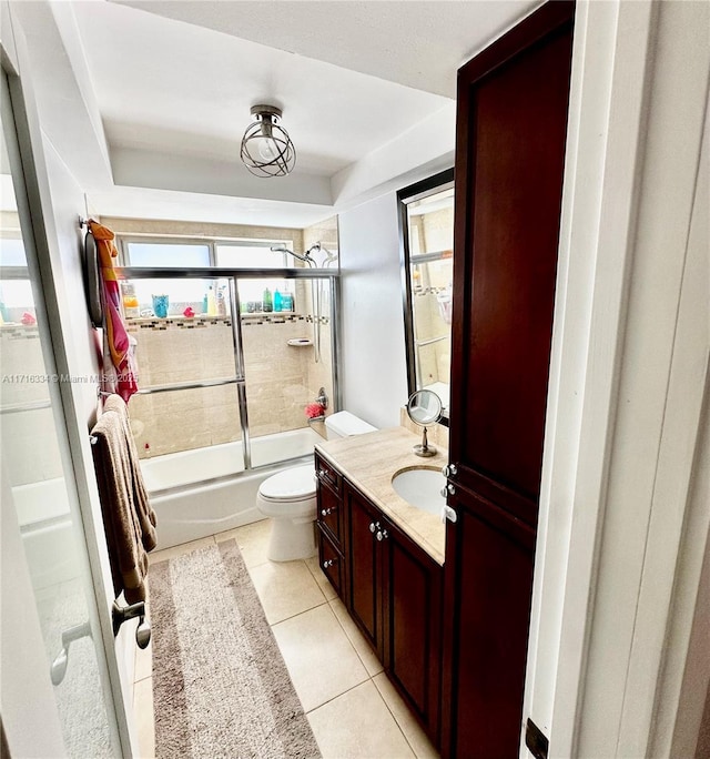 full bathroom with tile patterned floors, vanity, toilet, and enclosed tub / shower combo