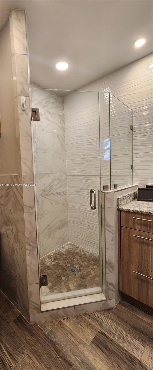 bathroom with hardwood / wood-style floors, vanity, and walk in shower