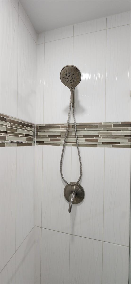 interior details with a tile shower