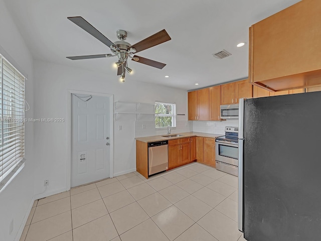 kitchen with sink, light tile patterned floors, ceiling fan, stainless steel appliances, and decorative backsplash