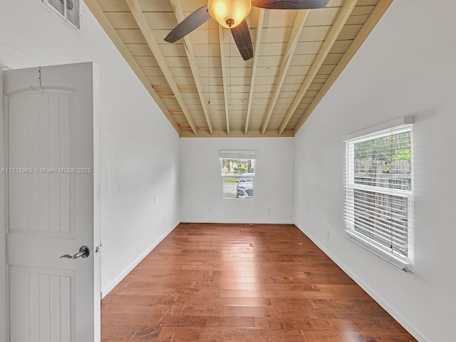 unfurnished room with vaulted ceiling with beams, wood ceiling, plenty of natural light, and hardwood / wood-style floors