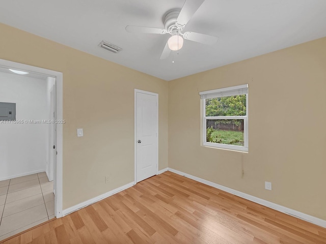 unfurnished bedroom with ceiling fan, electric panel, and light hardwood / wood-style floors