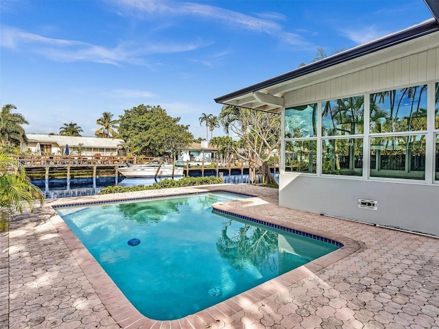 view of swimming pool with a patio area and a water view