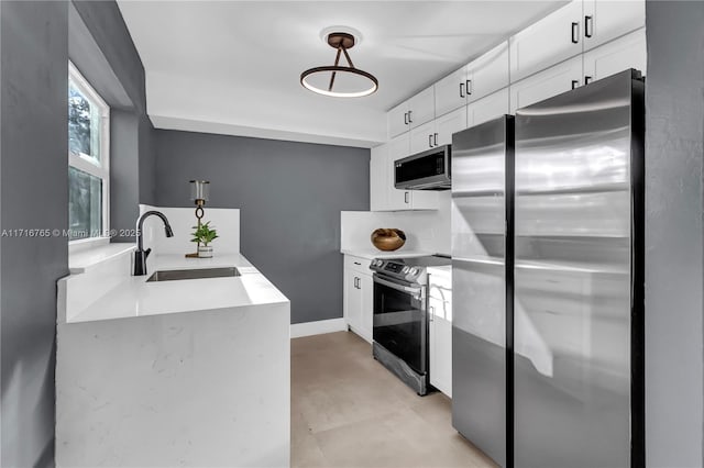 kitchen featuring white cabinets, appliances with stainless steel finishes, pendant lighting, and sink