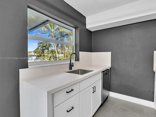 kitchen with dishwasher, white cabinetry, and sink