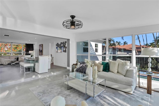 living room with ceiling fan and concrete flooring