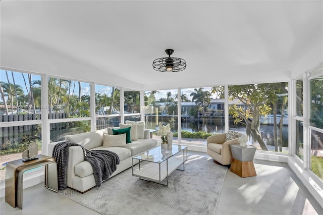 sunroom featuring ceiling fan and a water view