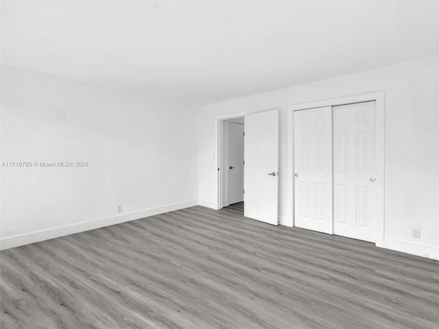 unfurnished bedroom featuring dark hardwood / wood-style floors and a closet