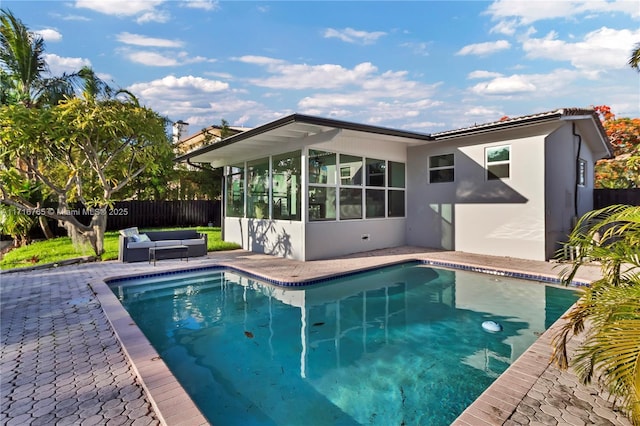 view of pool with an outdoor living space, a patio, and a sunroom