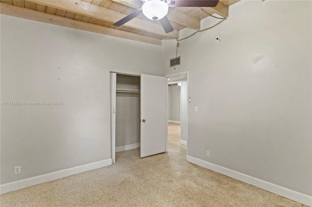 unfurnished bedroom featuring beam ceiling, a closet, ceiling fan, and wooden ceiling