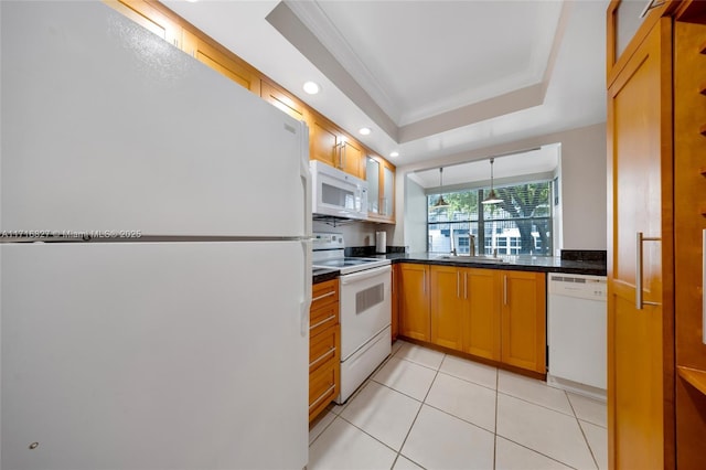 kitchen with white appliances, sink, crown molding, a tray ceiling, and light tile patterned flooring