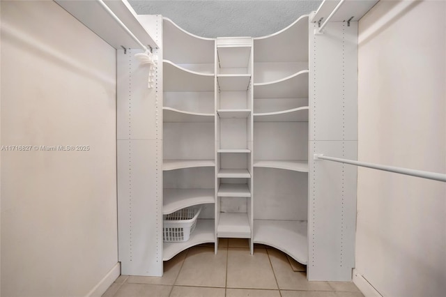 spacious closet featuring light tile patterned floors