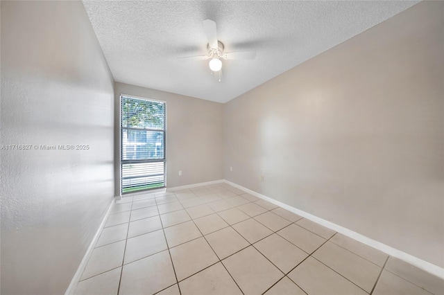 tiled empty room with ceiling fan and a textured ceiling