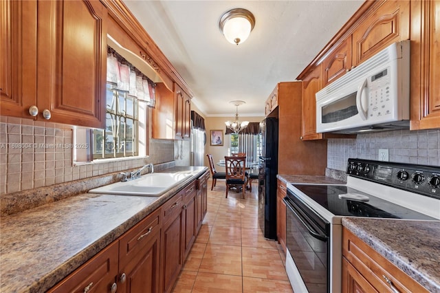 kitchen with sink, an inviting chandelier, tasteful backsplash, range with electric stovetop, and light tile patterned flooring