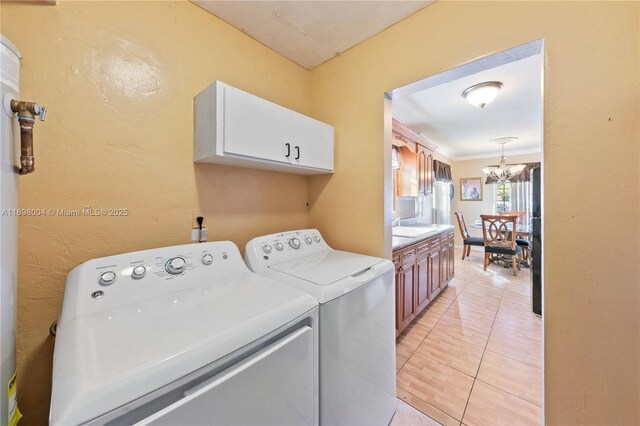 clothes washing area featuring sink, a notable chandelier, crown molding, washer and clothes dryer, and light tile patterned floors