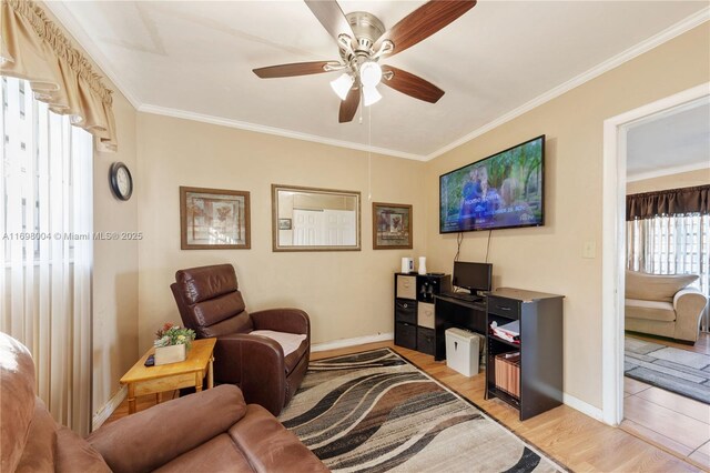 living room featuring crown molding, ceiling fan, and light hardwood / wood-style floors