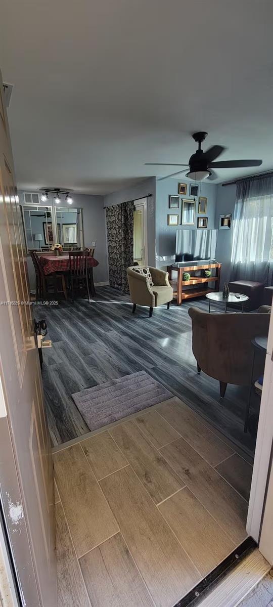 living room with wood-type flooring and ceiling fan