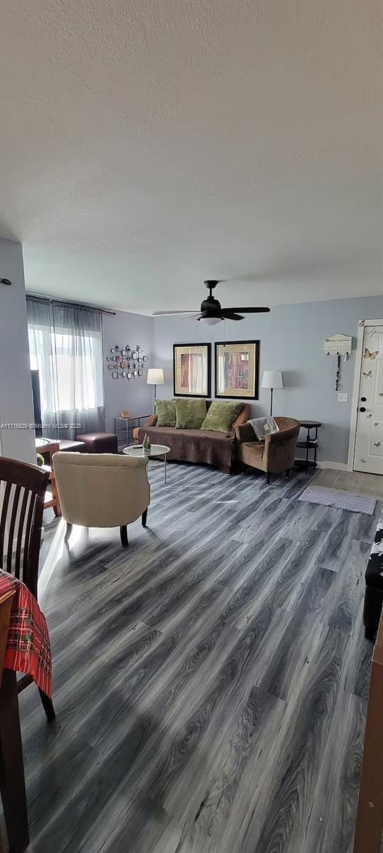 living room featuring ceiling fan, a textured ceiling, and hardwood / wood-style flooring