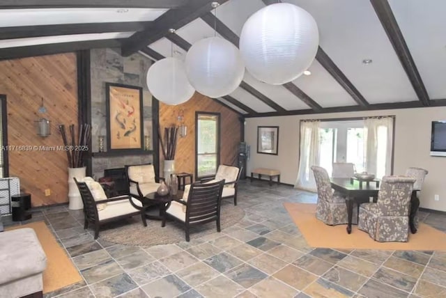 living room with lofted ceiling with beams and wood walls