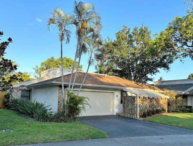 view of front of house with a garage, aphalt driveway, a front lawn, and stucco siding