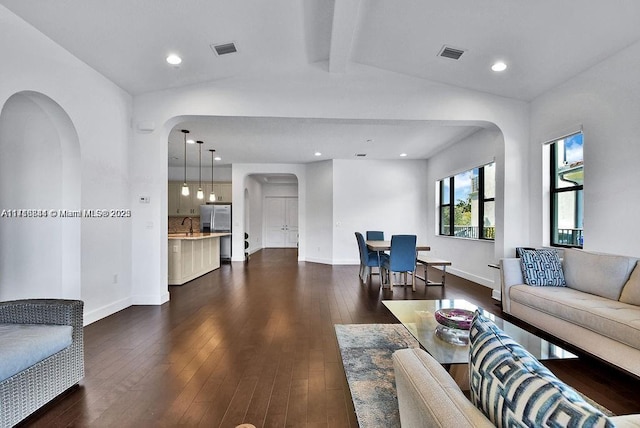 living room with vaulted ceiling with beams and dark hardwood / wood-style flooring