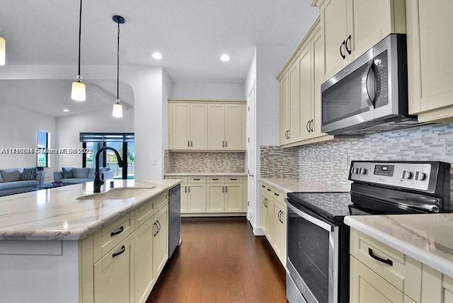 kitchen with backsplash, cream cabinets, appliances with stainless steel finishes, decorative light fixtures, and light stone counters