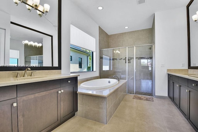 bathroom featuring tile patterned flooring, vanity, independent shower and bath, and a notable chandelier