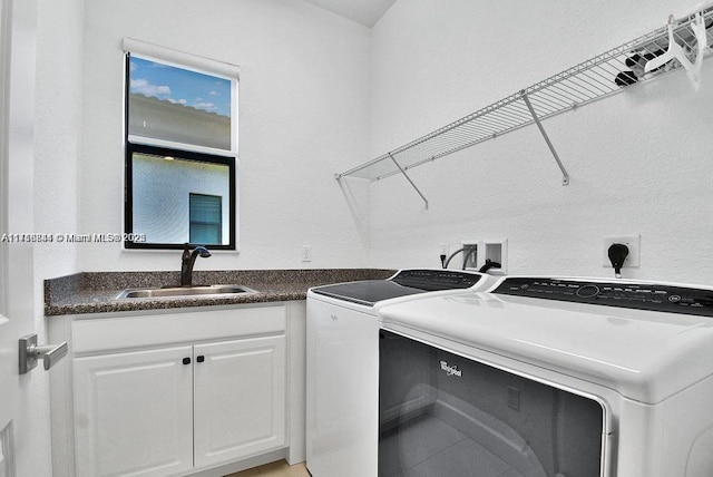 laundry room featuring cabinets, washer and clothes dryer, and sink