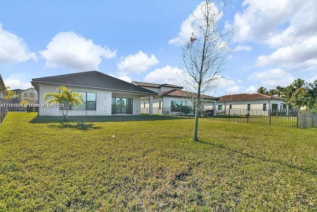 rear view of property featuring a lawn