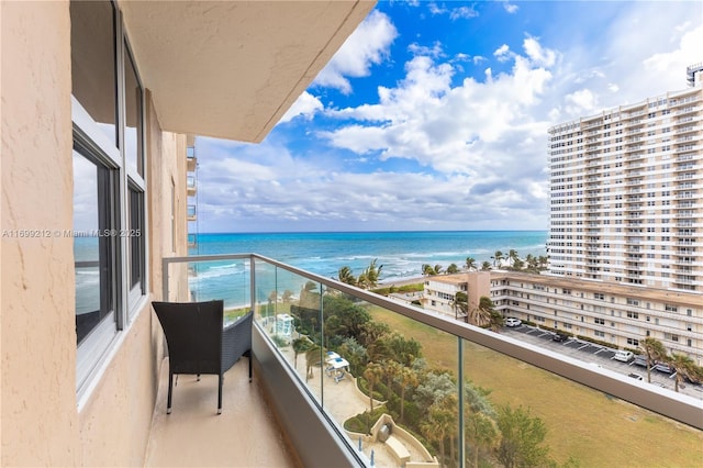 balcony featuring a water view and a view of the beach