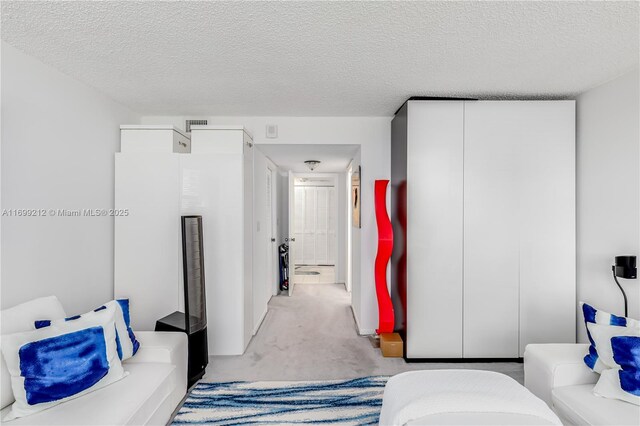 bedroom with a textured ceiling, carpet floors, and connected bathroom