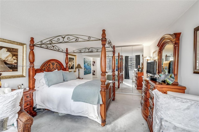 bedroom featuring a closet, light carpet, and a textured ceiling