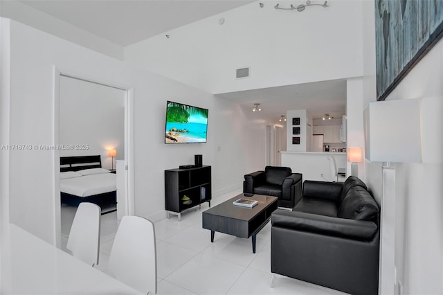 living room featuring light tile patterned floors and a towering ceiling