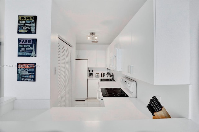 kitchen featuring white cabinetry, sink, white appliances, and a notable chandelier