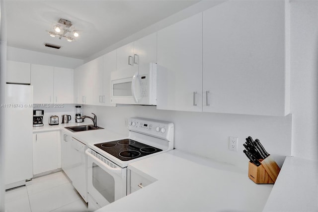 kitchen featuring white cabinetry, light tile patterned flooring, white appliances, and sink