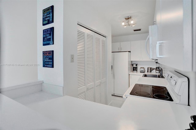 kitchen with white cabinetry, sink, white appliances, and an inviting chandelier