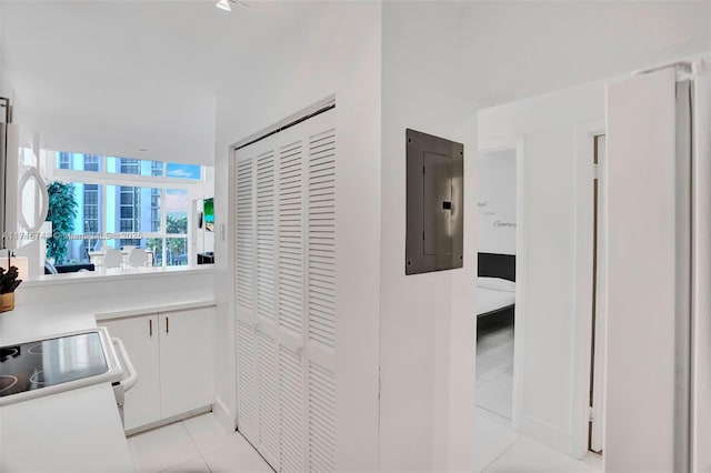 hallway with light tile patterned floors and electric panel