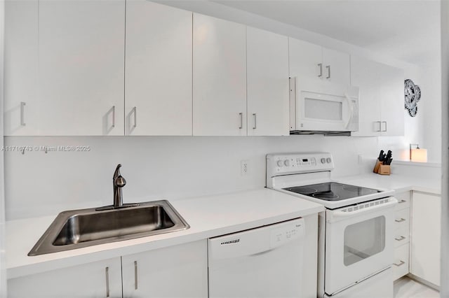 kitchen with white cabinets, white appliances, and sink