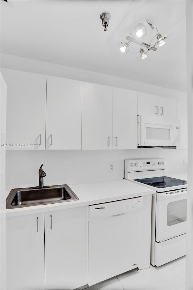 kitchen featuring white cabinetry, sink, light tile patterned floors, and white appliances