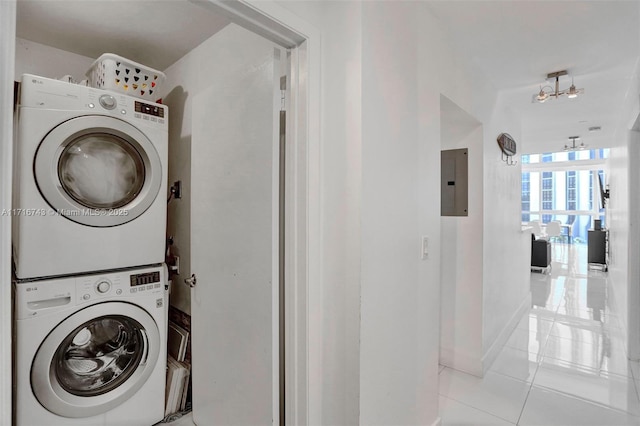 washroom featuring light tile patterned floors, electric panel, and stacked washer and clothes dryer