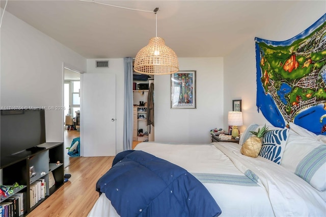 bedroom featuring visible vents and wood finished floors