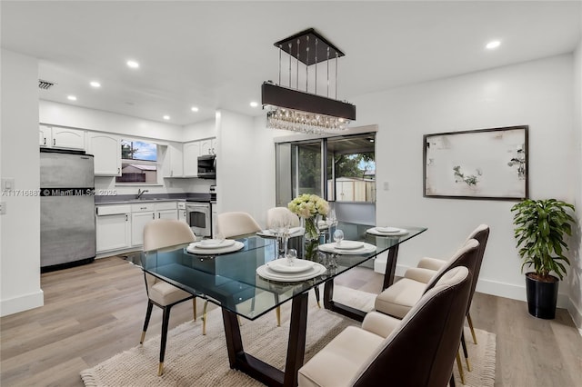 dining space featuring light hardwood / wood-style floors and sink