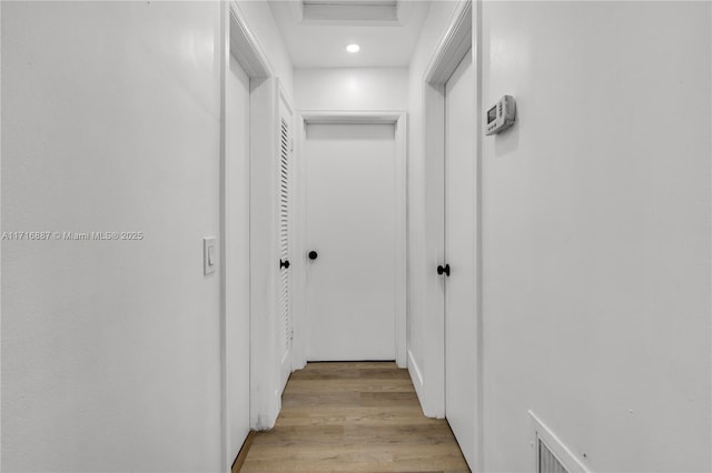 hallway with light hardwood / wood-style floors